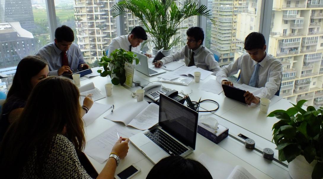 Projects Abroad Business Interns sit with professionals in a project meeting during their Business Internship in China. Business Interns sit around a table in a business meeting with proffessionals in China.